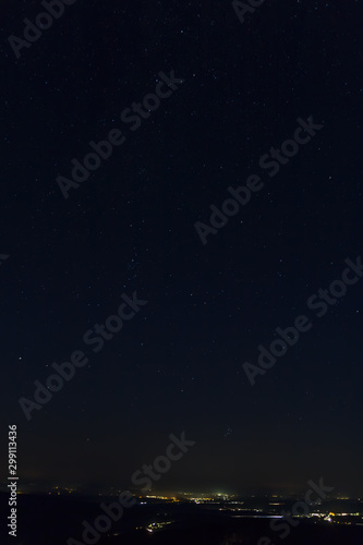 Night sky full of stars with distant city, long exposure, Austria landscape © Space Creator