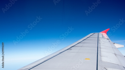 Looking through window aircraft during flight in wing with a nice blue sky.