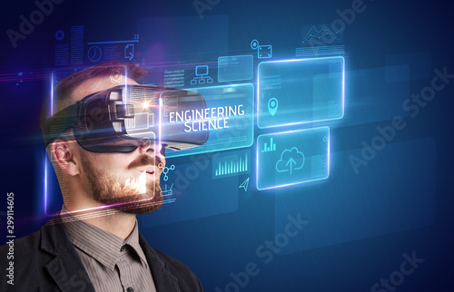 Businessman looking through Virtual Reality glasses with ENGINEERING SCIENCE inscription, new technology concept