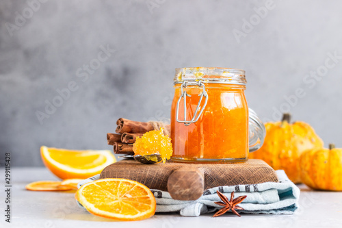 Pumpkin confiture (jam or marmalade) with oranges and spices (cinnamon and anise) on light grey background.