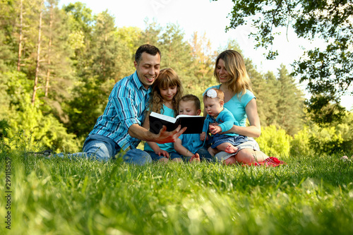 happy family reading the Bible in nature