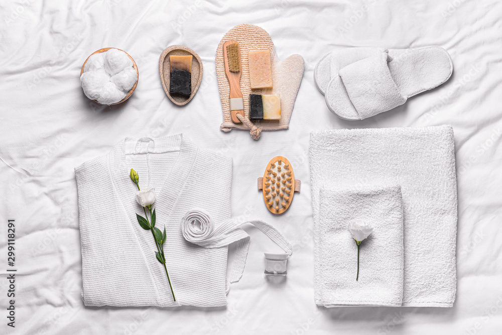 Clean bathrobe with spa supplies on white background - obrazy, fototapety, plakaty 