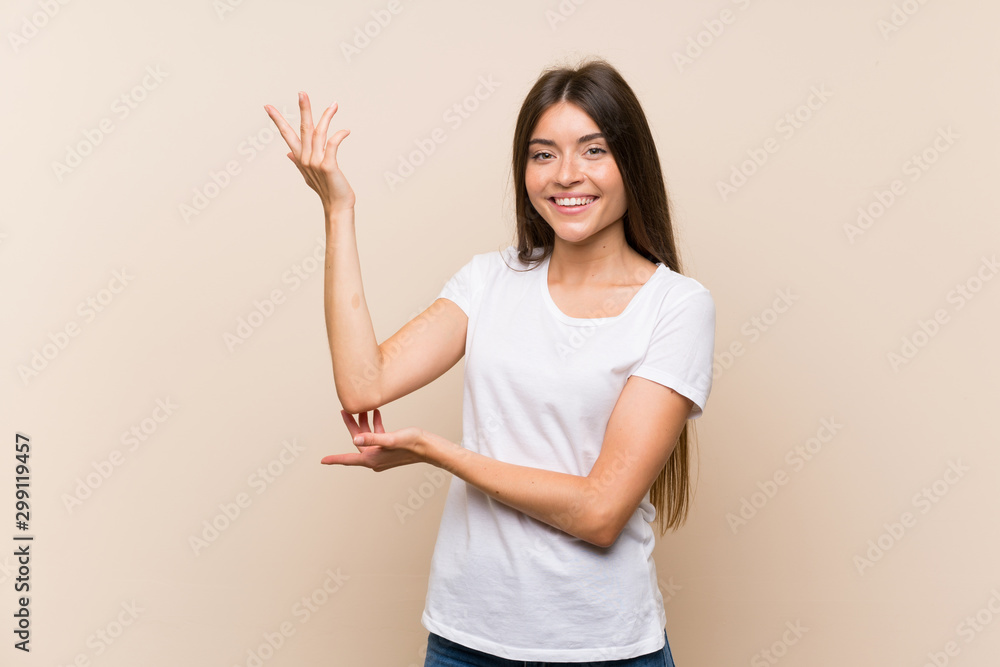 Pretty young girl over isolated background extending hands to the side for inviting to come Pretty young girl over isolated background extending hands to the side for inviting to come