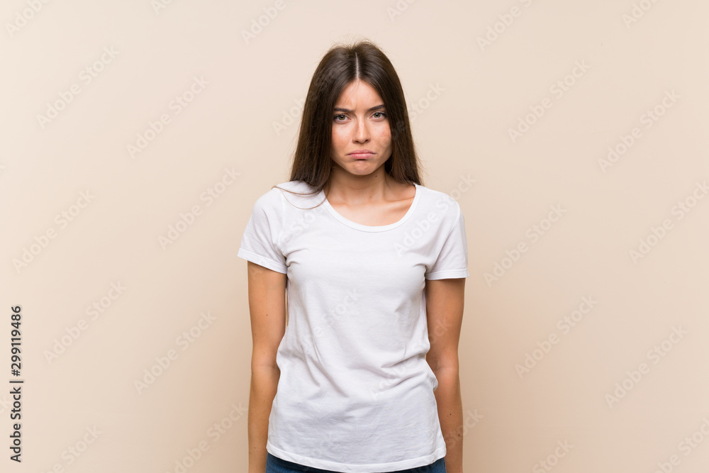 Pretty young girl over isolated background with sad and depressed expression Pretty young girl over isolated background with sad and depressed expression