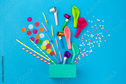 celebration and decoration concept - gift box and birthday party props on blue background photo