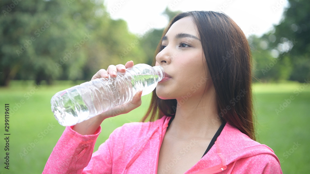 Exercise concepts. Beautiful women are drinking water with freshness in the park. 4k Resolution. Exercise concepts. Beautiful women are drinking water with freshness in the park. 4k Resolution.