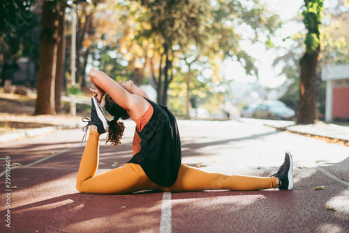 Young woman stretching. Morning workout outdoors, sports and healthy lifestyle.
