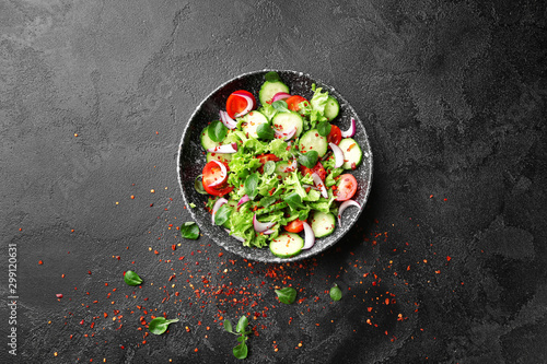 Plate with fresh vegetable salad on dark background