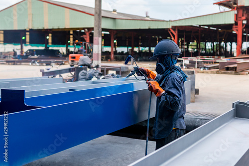 The painter is working to painting the steel structure with spray gun, at Industrial factory.	