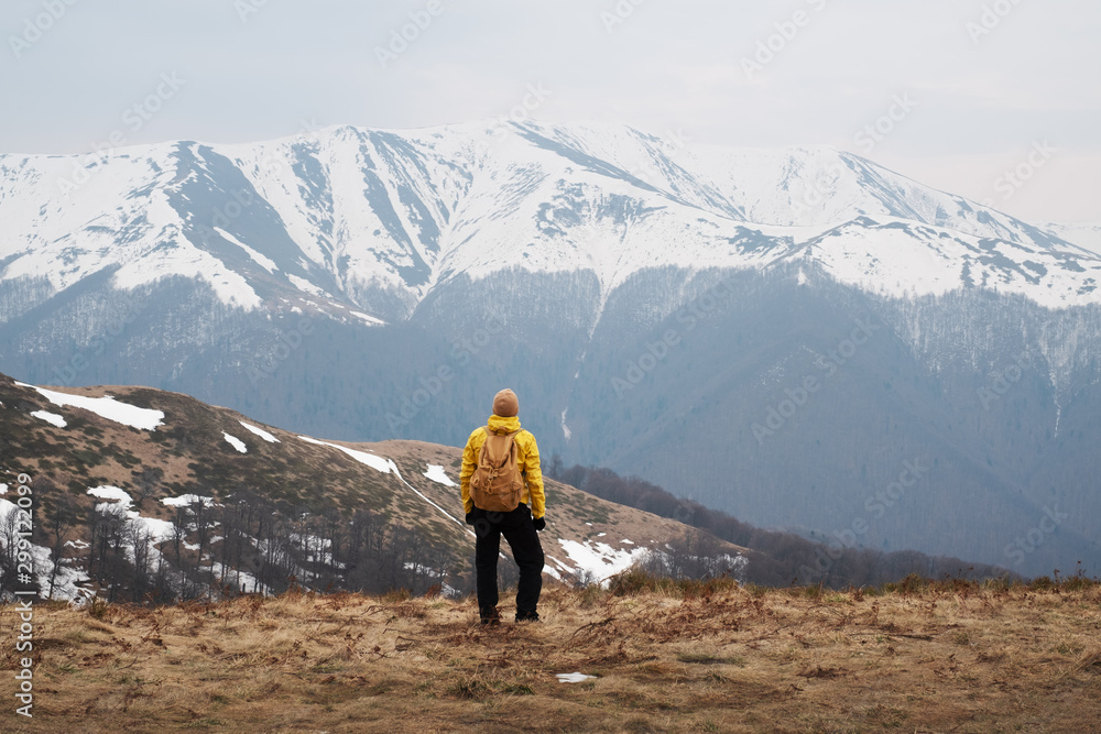 Man with backpack in spring snowy mountains. Travel concept. Landscape photography