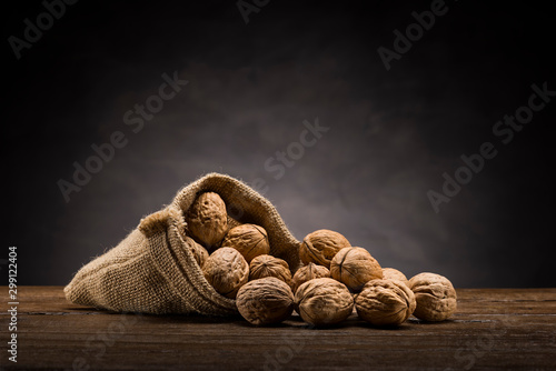 walnuts in jute bag on wooden table