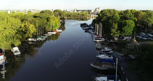 Aerial drone scene flying above river delta with moorings at both shores. Sailboats, yates. Gualeguaychu city at background. Entre rios, Argentina. photo