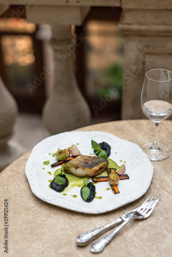 Roasted Sea Bass with Grilled Vegetables on White Plate.