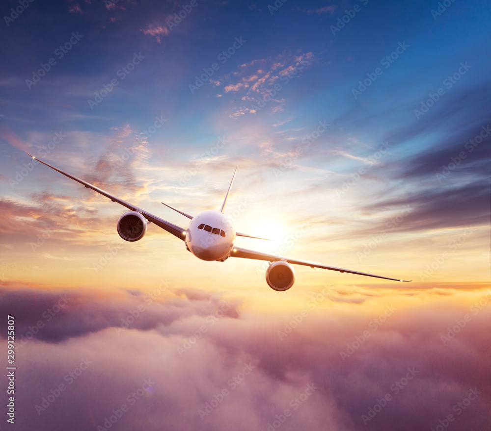 Fototapeta Commercial airplane flying over dramatic sunset