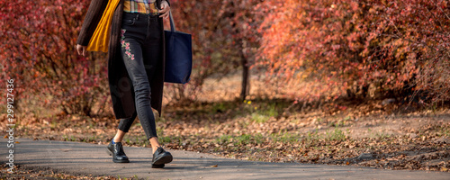 Closeup legs fashionable woman wear black shoes and brown coat. Stylish fall outfit photo