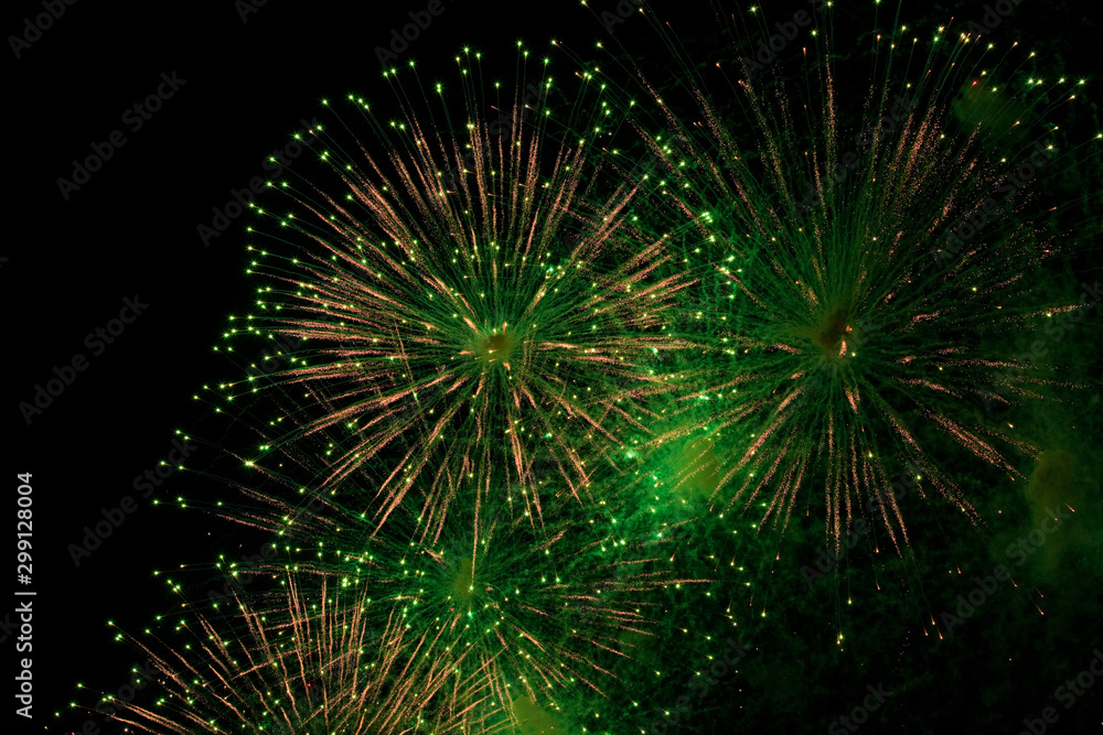 green and golden sparks of fireworks exploding in the sky and smoke from the charges green and golden sparks of fireworks exploding in the sky and smoke from the charges