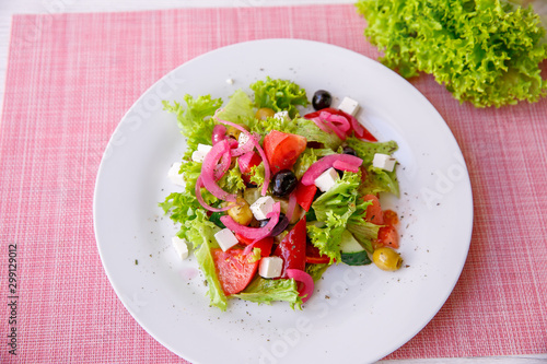 Tasty fresh Greek salad on white wooden table,