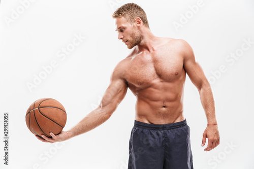 Focused young fit sportsman playing basketball
