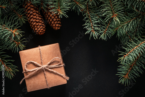 A frame of fir branches and  gift paper box tied with twine. Christmas card blank.