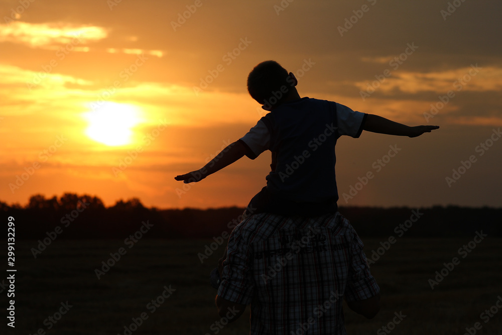 Fototapeta premium silhouette of father and son on sunset