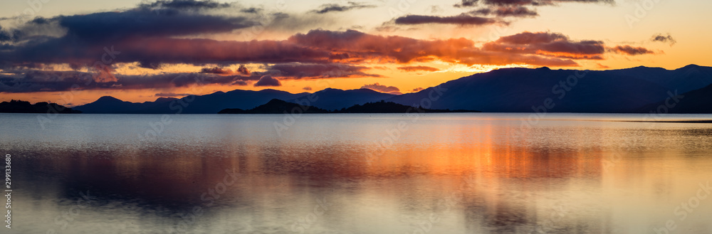 loch linnhe in the argyll region of the highlands of scotland during an autumn sunset showing golden light on the clouds and water and the islands of lismore and shuna