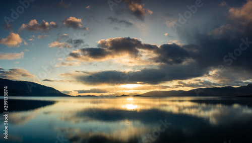 loch linnhe in the argyll region of the highlands of scotland during an autumn sunset showing golden light on the clouds and water and the islands of lismore and shuna