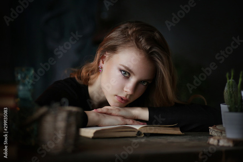 Studio portrait of young beautiful woman with book