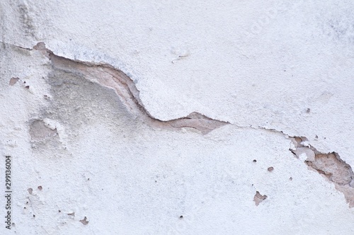 Cracked Broken Destroyed Weathered Plaster Paint on the Exterior White Wall