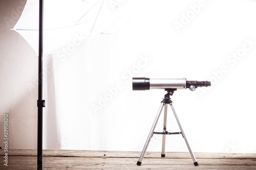 telescope on a white background laid on wooden board
