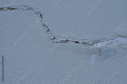 Cracked Broken Destroyed Weathered Plaster Paint on the Exterior White Wall