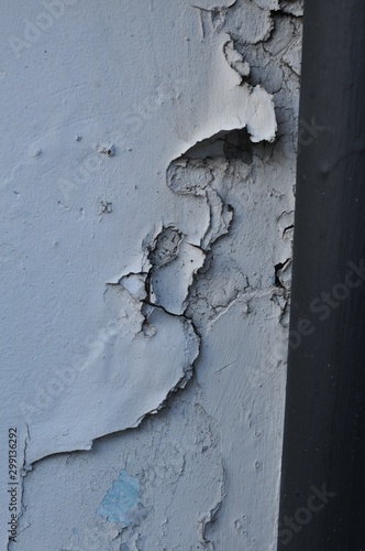 Cracked Broken Destroyed Weathered Plaster Paint on the Exterior White Wall