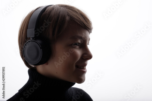 Beautiful boy in headphones listening music. White background.