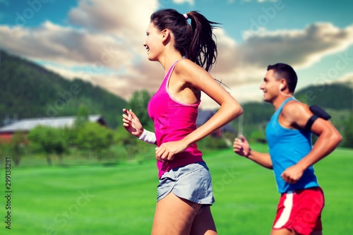 Fitness, sport, friendship and lifestyle concept - smiling couple running together