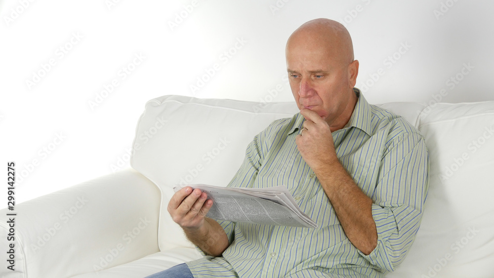 Man Reading Relaxed a Newspaper Sitting on the Sofa