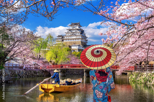Fotografie, Tablou Asian woman wearing japanese traditional kimono looking at cherry blossoms and castle in Himeji, Japan