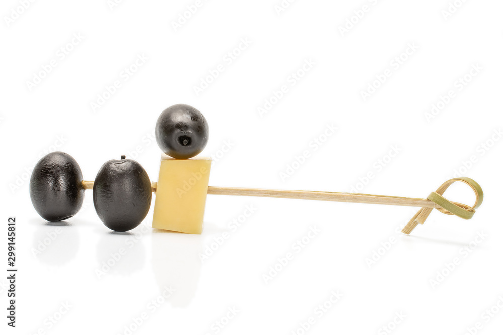 Group of three whole canned black olive with bamboo skewer and piece of cheese isolated on white background Group of three whole canned black olive with bamboo skewer and piece of cheese isolated on white background