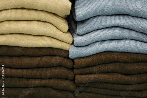 Warm clothing neatly folded on a store shelf. Clothes storage. Size range.