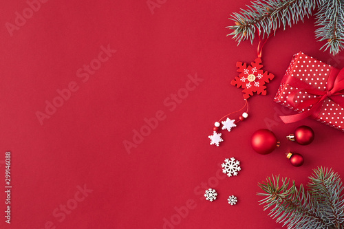 Flat lay border with branches spruce  red balls and christmas decoration on a red background