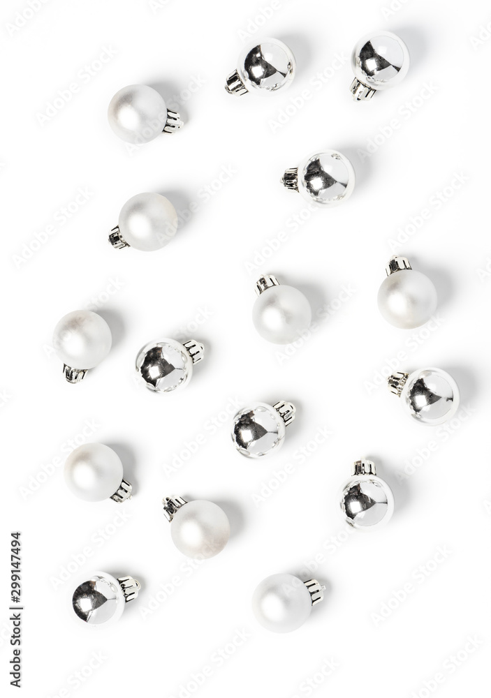 White and silver christmas balls pattern, minimal style. Christmas decorations on a white background, top view, flat lay.