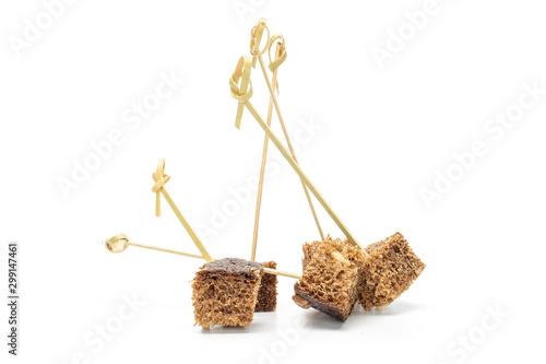 Group of five pieces of fresh baked dark bread with bamboo skewer isolated on white background