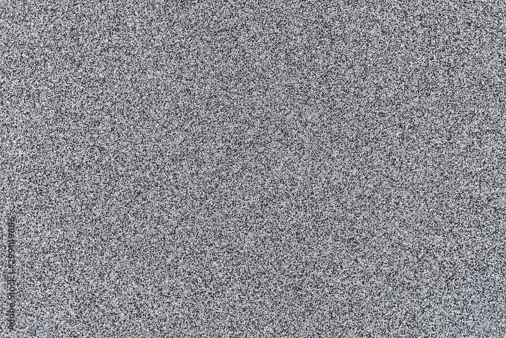 Fototapeta premium A smooth light grey asphalt pavement texture with small rocks