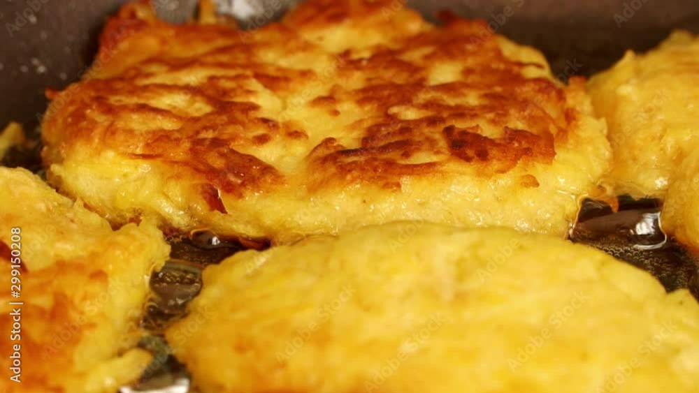 Close up of zucchini fritters fried in boiling oil on hot pan. Vegan food concept Close up of zucchini fritters fried in boiling oil on hot pan. Vegan food concept
