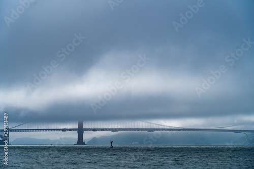 The marine layer is thick and almost completely obscures this view of a bridge over the bay