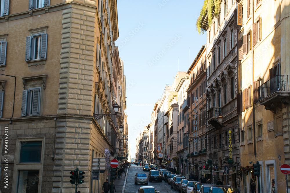 Italy, Rome - December 10, 2018. Street of Rome, italian buildings people and cars at sunny day. Daily life of Rome