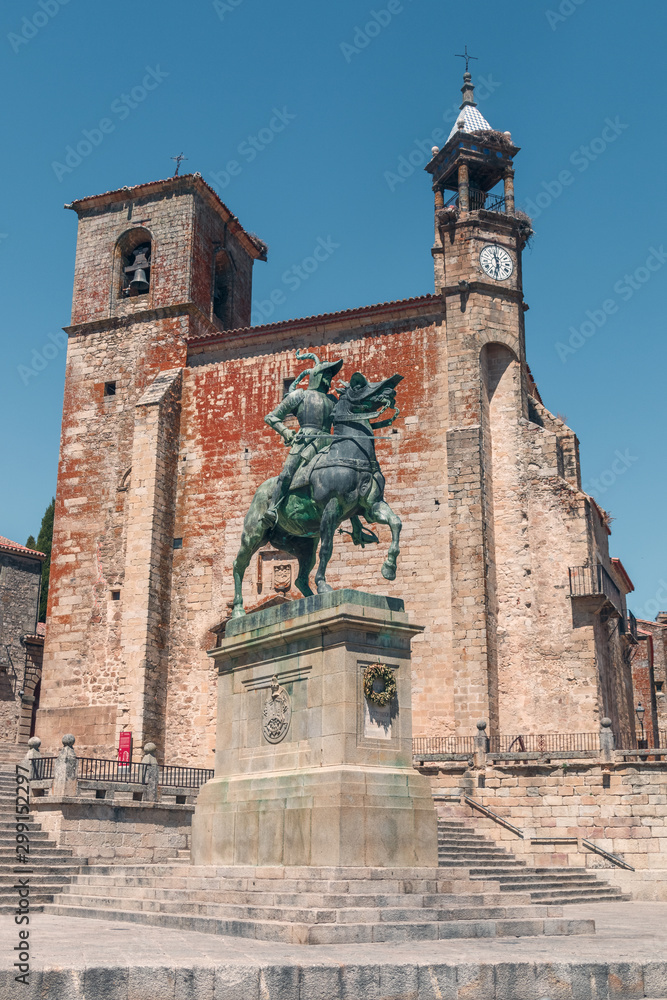 TRUJILLO, EXTREMADURA, SPAIN - AUGUST 08, 2019: Saint Martin´s Church and statue os Francisco Pizarro in Main square. Tourists in streets of Trujillo