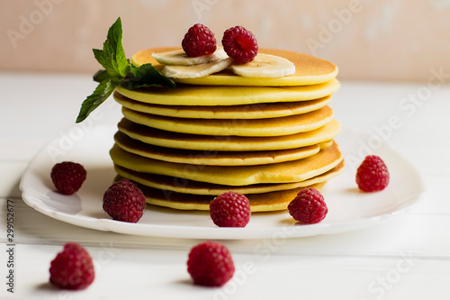 pancakes with raspberries on a white plate