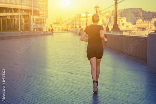 Londoner lifestyle women running near tower bridge. Female runner jogging training in city Fitness girl happy life with sports, London, England, United Kingdom. in the morning ,color tone of sunrise