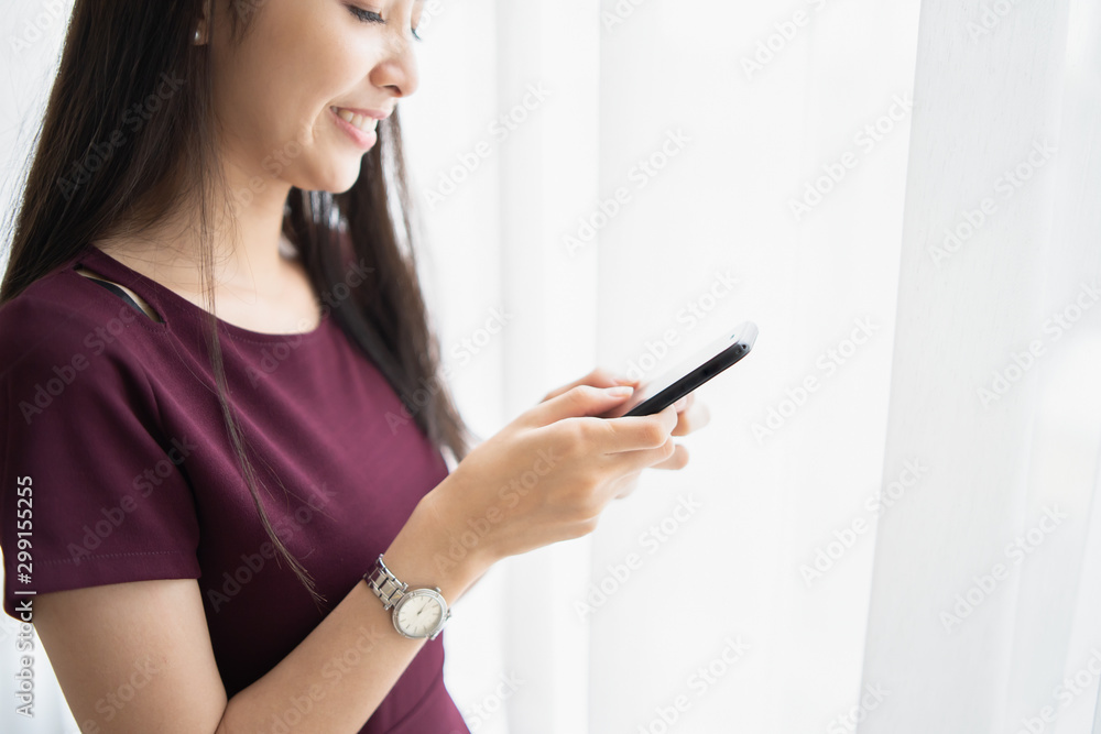 Young Asian woman serving internet she looking a smartphone,messaging and smiling while sitting on carpet near sofa at home,lifestyle,Social networks for sale product, shopping, fashion asia people Young Asian woman serving internet she looking a smartphone,messaging and smiling while sitting on carpet near sofa at home,lifestyle,Social networks for sale product, shopping, fashion asia people