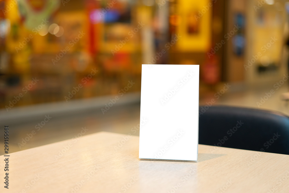 Mock up Label the blank menu frame in Bar restaurant ,Stand for booklets with white sheets paper acrylic tent card on wooden table cafeteria blurred background can inserting the text of the customer. Mock up Label the blank menu frame in Bar restaurant ,Stand for booklets with white sheets paper acrylic tent card on wooden table cafeteria blurred background can inserting the text of the customer.