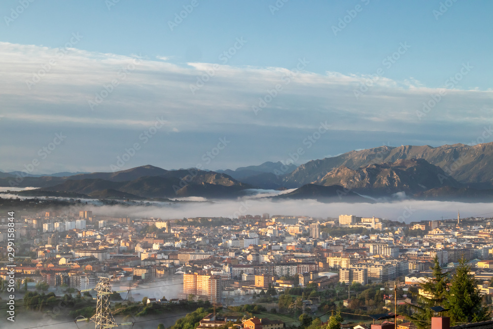 Oviedo city aerial panoramic sunrise foggy view from a mountain viewpoint near Oviedo, Spain